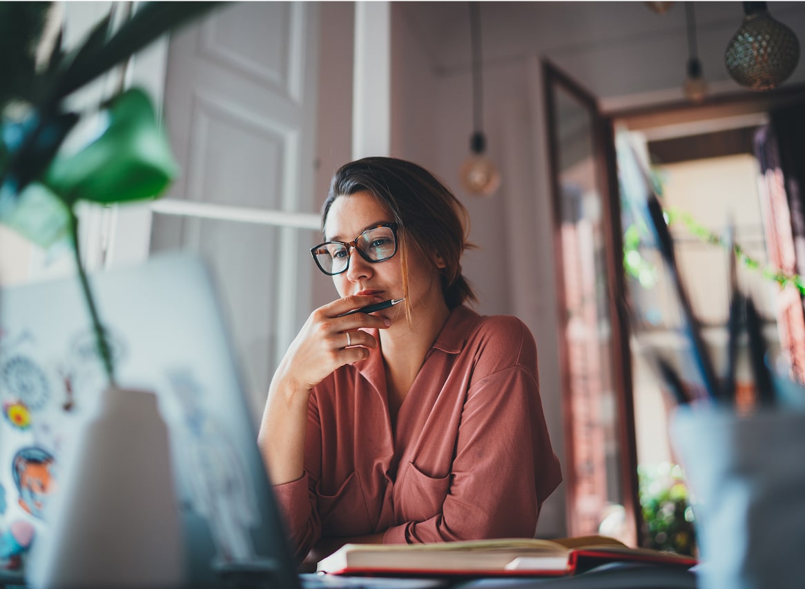 Individual thinking at work in front of a laptop